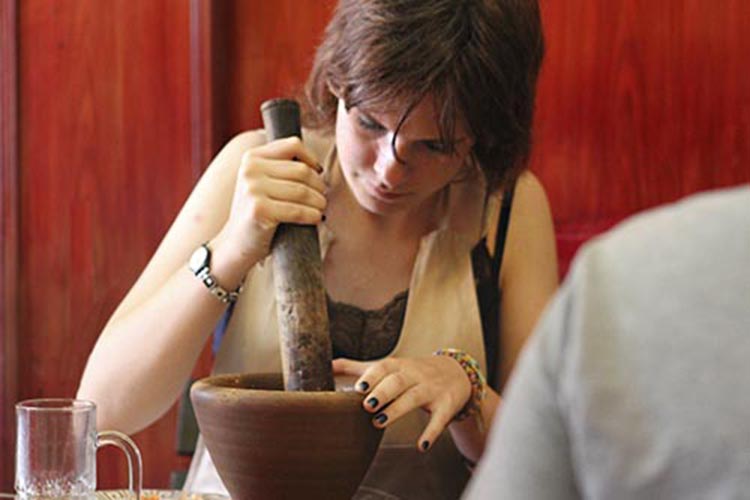 Student making chili paste with a mortar and pestle