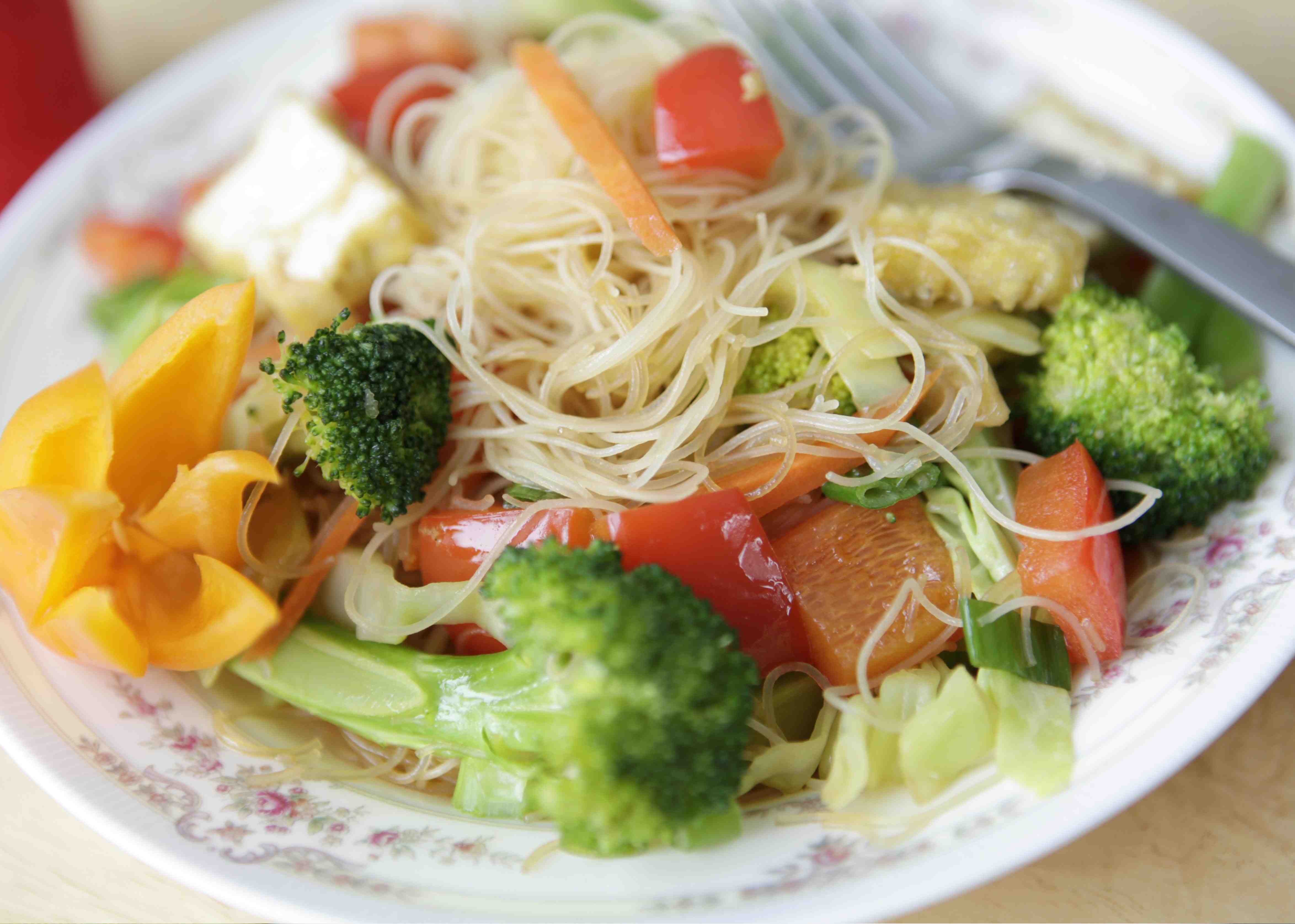 Noodle salad on a decorative ceramic plate.